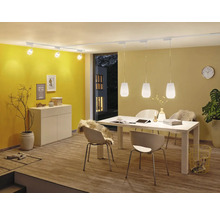 Matsal med matbord, stolar, skänk, takspotlights och pendellampor.