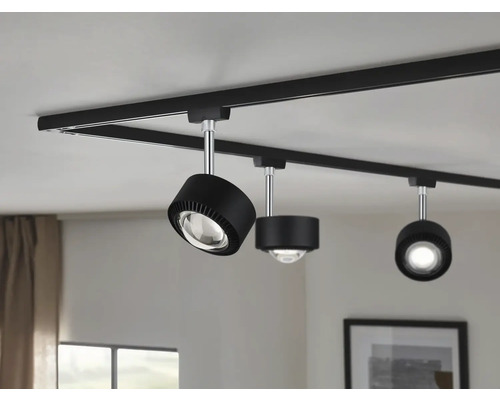 Svart skensystem med tre spotlights i taket.