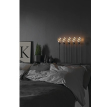 Dekorativt sovrum med säng, sänglampa med fem glödlampor, krukväxt och bild