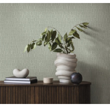 Vardagsrum med mönstrad tapet, skänk, böcker och dekoration