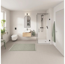 Badrum med dusch, handfat, spegel och toalett i ljus design