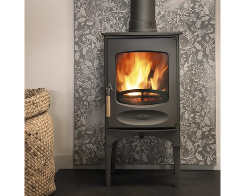 Kamin med vedkorg och mönstrad väggbeklädnad