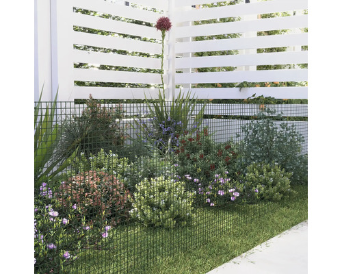 Trädgårdsscen med staket, plantering och gräsmatta