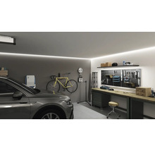 Garage med bil, cykel, arbetsbänk och verktygsvägg.