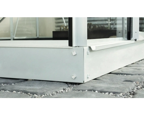 Detaljvy av ett växthus med grundram på stenbeläggning