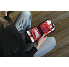 Person håller en öppen första hjälpen-låda med förbandsmaterial.
