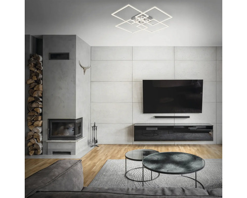 Vardagsrum med öppen spis, TV och modern taklampa