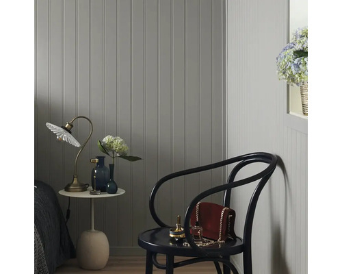 Mysig hörna av rummet med väggpaneler, bordslampa och trästol