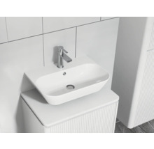 Modern badrumshandfat med kran på ett tvättställsskåp med räfflad struktur.