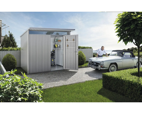 Metallträdgårdshus med öppna dörrar och man som putsar en bil