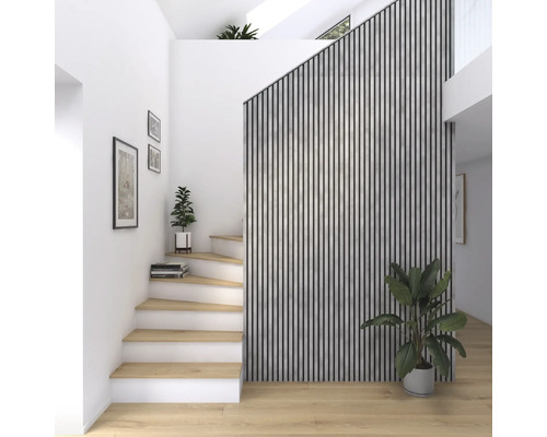 Ljus hall med trappa, väggbeklädnad av trälameller och krukväxter.