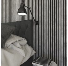 Sovrum med väggpaneler, säng och vägglampa