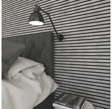 Sovrum med säng, väggpaneler och justerbar vägglampa