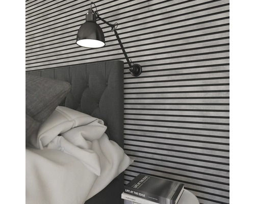 Sovrum med säng, väggpaneler och justerbar vägglampa