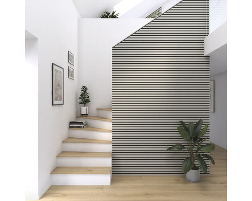 Ljus hall med trappa, trätrappsteg och akustikpaneler på väggen