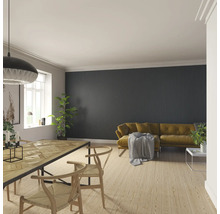 Vardagsrum med matbord, stolar och soffa framför en vägg med träpaneler