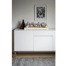 Dekorativt jullandskap med hus, träd och tåg på en skänk