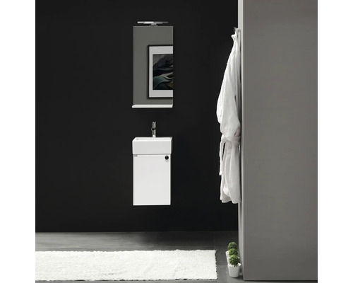 Modernt badrum med tvättställ, spegel, badrock och matta