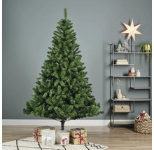 Konstgjord grön julgran med presenter i vardagsrummet.