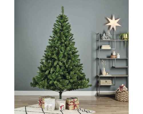 Konstgjord grön julgran med presenter i vardagsrummet.