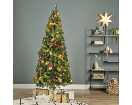 Dekorerad julgran med presenter i vardagsrummet