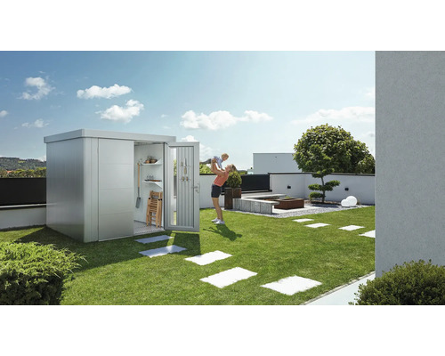 Trädgårdsscen med redskapsbod, mor och barn på gräsmatta