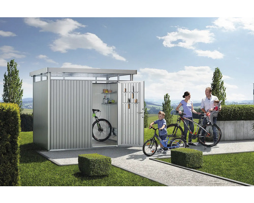 Familj med cyklar framför cykelgarage i metall i trädgården