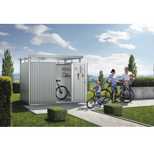 Familj med cyklar framför cykelgarage i trädgården