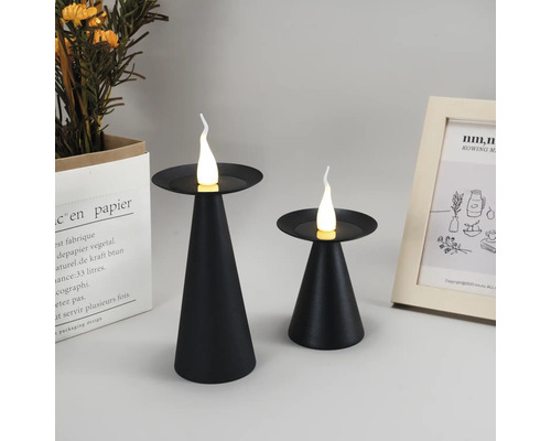 Två svarta ljusstakar med LED-ljus på ett bord