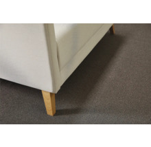 Detaljbild av en soffa med tygklädsel och träben