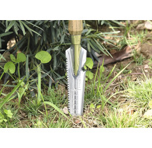 Trädgårdsredskap med trähandtag och rostfri stålspade i gräset