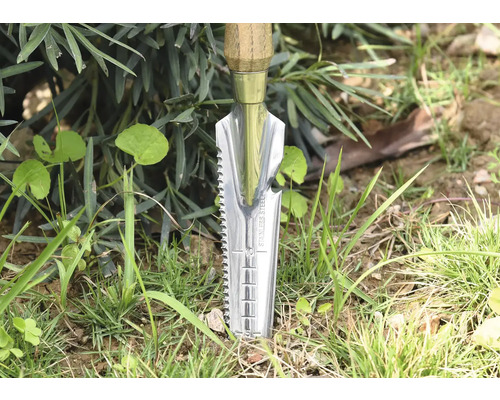 Trädgårdsredskap med trähandtag och rostfri stålspade i gräset