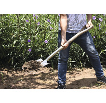 Person med spade i trädgården som vänder jord