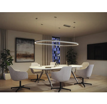 Modernt kontor med oval pendellampa över ett konferensbord, omgivet av kontorsstolar.