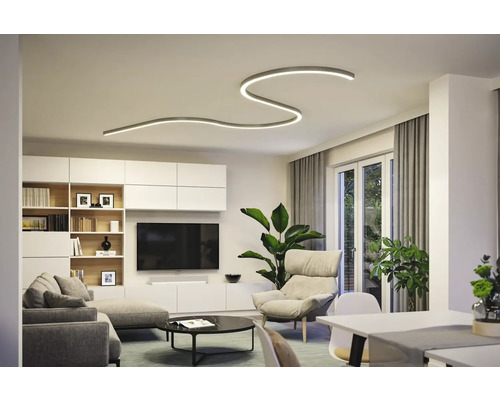 Modernt vardagsrum med böjd taklampa, soffa och tv-vägg