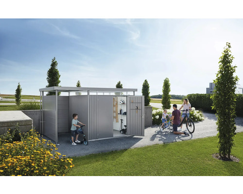 Familj framför cykelgarage i trädgården med cyklar och sparkcyklar