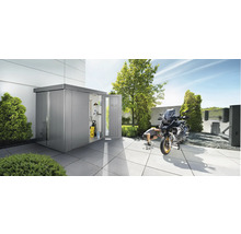 Metallförråd med öppen dörr och motorcykel på en terrass