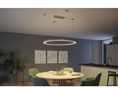 Matsal med matbord, stolar och en rund LED-pendellampa.