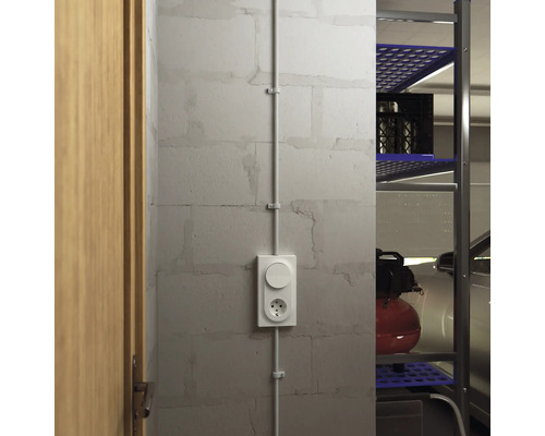 Utanpåliggande uttag med ljusbrytare på en vägg