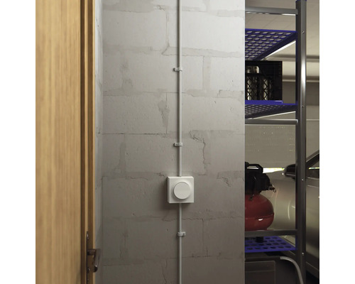 Rumsscen med utanpåliggande strömbrytare och kabelkanal på en vägg