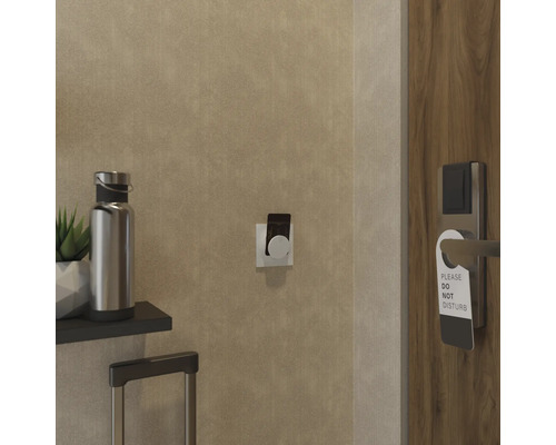 Detalj av ett hotellrum med dörrskylt, bagage och vattenflaska.