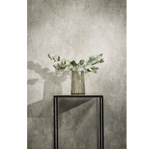 Dekorativa eukalyptusgrenar i en glasvas på ett svart metallbord