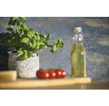 Stilleben med basilika i kruka, tomater och en flaska olja på ett träbord.