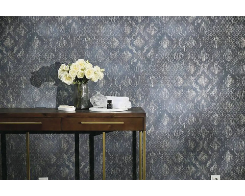 Dekorativ väggdesign med mönstrad tapet, konsol, blommor och tillbehör