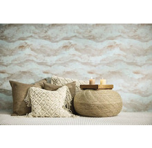 Vardagsrum med mönstrad tapet, prydnadskuddar och sittpuff