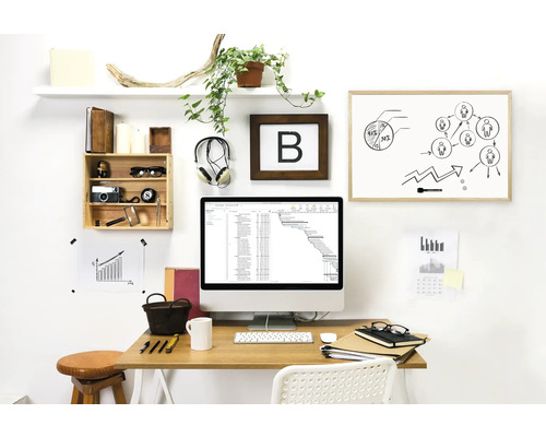 Arbetsrum med skrivbord, dator, whiteboard och dekorationer för en organiserad och ljus atmosfär