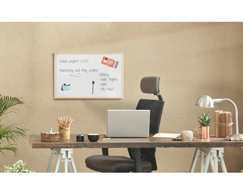 Skrivbord med whiteboard, kontorsmaterial och bärbar dator för kontorsorganisation