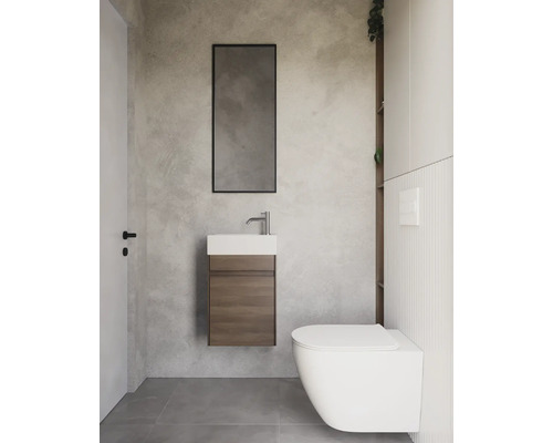 Modernt badrum med handfat, spegel och toalett.