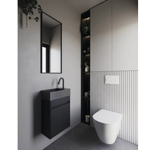 Modernt badrum med vägghängd toalett, handfat och spegel