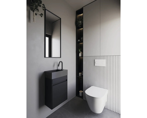 Modernt badrum med vägghängd toalett, handfat och spegel